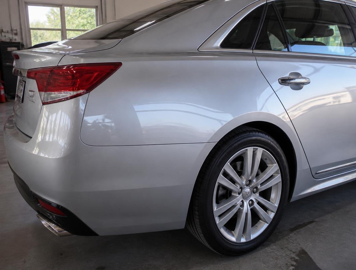 Same silver sedan rear quarter panel after collision repair with straight body lines and a glossy color-matched finish